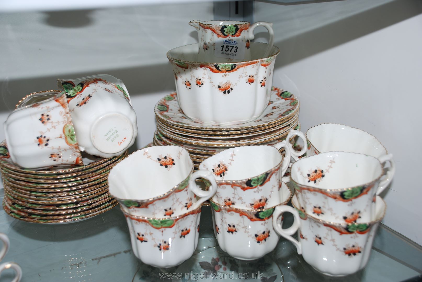 A twelve setting bone china Teaset in floral pattern with swags in orange and green, blue and white,