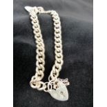 Sterling silver charm bracelet with padlock clasp.