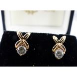 Pair of boxed gold and CZ stud earrings.