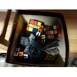 Small box containing numerous Rubik's cubes etc