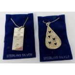 Two sterling silver pendants on chains ~ silver ingot with bird and foliage design, and a textured