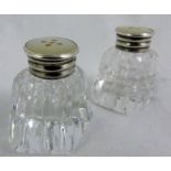 Pair of cut glass pepperettes with silver and mother of pearl tops