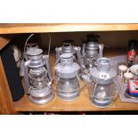 Six retro style aluminium and glass hurricane lamps