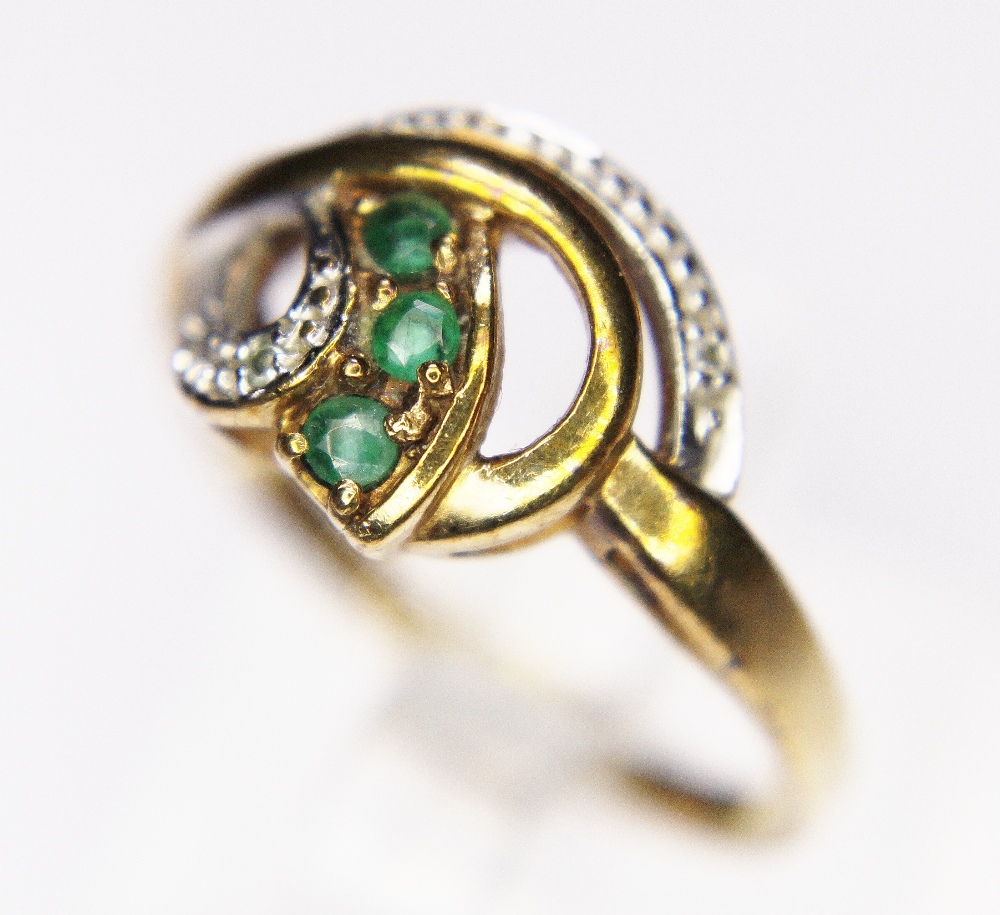 GOLD TWIST RING. 9ct yellow gold diamond and emerald set twist ring, size N