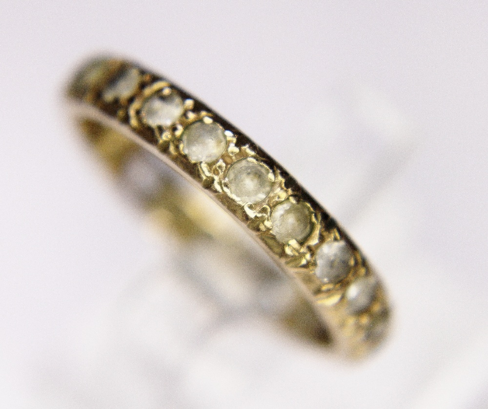 GOLD ETERNITY RING. 9ct yellow gold stone set eternity ring, size P