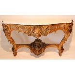 CONSOLE EN BOIS DORE DE STYLE LOUIS XV Comprenant quatre pieds galbés décalés, reliés par une