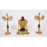 GARNITURE DE CHEMINEE EN BRONZE DORE ET PATINE DE STYLE LOUIS XV Comprenant une pendule centrale