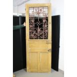 DOOR - a heavy wooden door featuring a metal inset with a leaf motif measuring 85"x31".