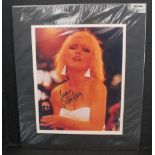 DEBBIE HARRY - a card framed photograph of Debbie Harry mid performance, signed 'Love Debbie Harry'.