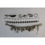 JEWELLERY - a silver charm bracelet containing 15 charms of which 10 are silver (total weight of