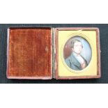 PORTRAIT MINIATURE - a early C19th miniature of a young gentleman painted on Ivory in a leather