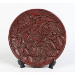 A Chinese cinnabar lacquer dish. Carved in high relief with  stylized peonies and overlapping