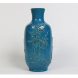 A Chinese high shouldered vase with turquoise glaze. Moulded in relief with a continuing landscape