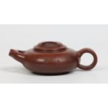 A Chinese Yixing teapot of compressed form and with a Y shaped spout and incised characters to the