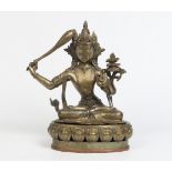 An Antique Eastern bronze figure probably Tibetan seventeenth century. Formed as a seated Manjusri