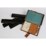 An early twentieth century Mah jong set in leather case and with four lacquered tile stands.