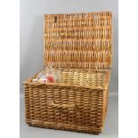 A wicker work picnic basket and contents