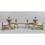 A three piece brass companion set on pair of fire dogs along with another pair of ornate brass fire