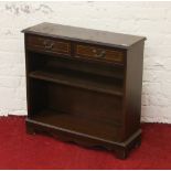 A small inlaid mahogany open fronted bookcase raised on bracket feet.