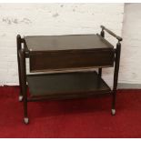 An Ercol style mahogany dropleaf tea trolley raised on turned supports.