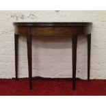 A Victorian mahogany fold over demi lune side table raised on tapering supports.