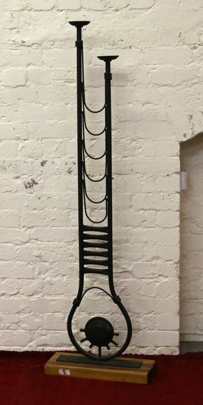A decorative wrought iron two branch floor standing candle holder.