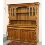 A large carved pine kitchen dresser the top section with glazed cupboards and six spice drawers.