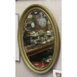 An oval gilt framed bevel edge wall mirror.