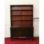 A large mahogany open fronted bookcase over cupboard base and raised on tapering spade feet.
