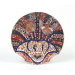 A large Japanese Imari dish in the form of a scallop shell, painted with stylized panels and