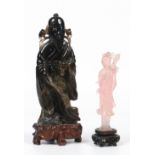 A Chinese carved smokey quartz figure of a sage. Holding a branch across his shoulder and with a