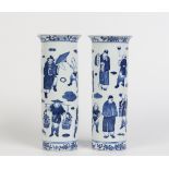 A pair of Chinese blue and white sleeve vases. Having everted rims and painted with figures at