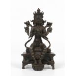 A mid nineteenth century Oriental bronze figure of a seated Buddhistic deity seated upon a lotus