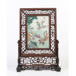 A Chinese late Qing dynasty large hardwood table screen. With open fret carving framing a famille