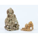 Two Chinese carved soapstone figure groups. One formed as a lohan riding upon a mythical beast, pale