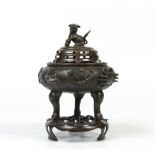 A Japanese bronze koro with cover and stand. Surmounted with a dog of fo finial and fish to the main