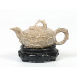 A twentieth century Chinese carved soapstone miniature teapot and cover on associated hardwood