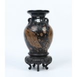 A Chinese earthenware baluster vase on lacquered stand. With loop handles, black ground and