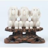 A Cantonese carved ivory figure group raised on a hardwood plinth. Formed as the three wise