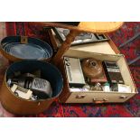 A suite case and metal hat box containing a copper bed warmer and projector,