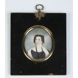 A Regency ivory portrait miniature in ebonized frame depicting a lady with ringlets in her hair.