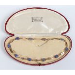A ladies cased gold necklace with wide pierced links and set with ten moonstones, 37cm. Condition