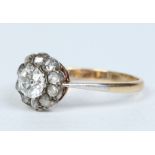 An Edwardian 18 carat gold diamond cluster ring. Set with an old European cut stone approximately