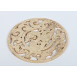 A Chinese calcified jade pierced roundel medallion decorated with stylized mythical beasts, 13.25cm.