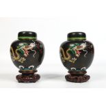 A pair of twentieth century Chinese cloisonne ginger jars and covers raised on carved hardwood