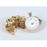 A ladies early twentieth century yellow metal lapel watch. Suspended on a bow shaped brooch with old