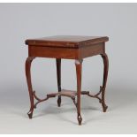 An Edwardian mahogany envelope games table raised on slender scrolling supports and opening to