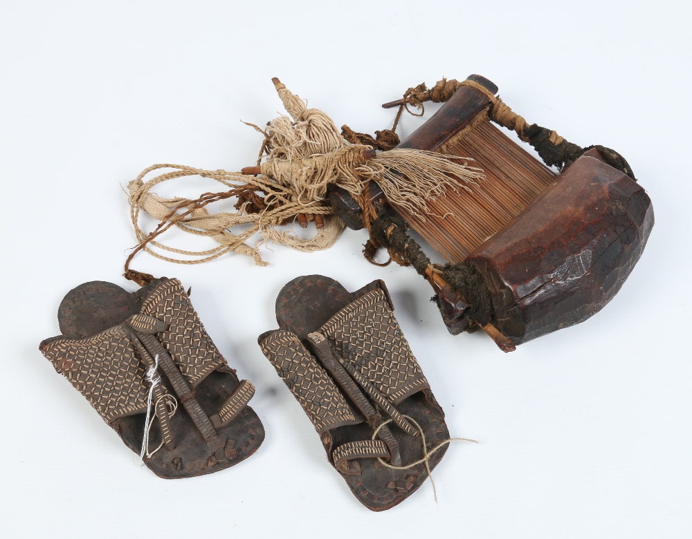 A tribal weaving loom and a pair of leather sandals possibly Inuit.