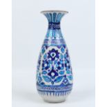 An antique middle Eastern glazed earthenware vase in Iznik style. Decorated in tones of blue with