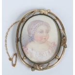 A Victorian pinchbeck brooch set with an ivory portrait miniature of a baby, 6.5cm. Condition